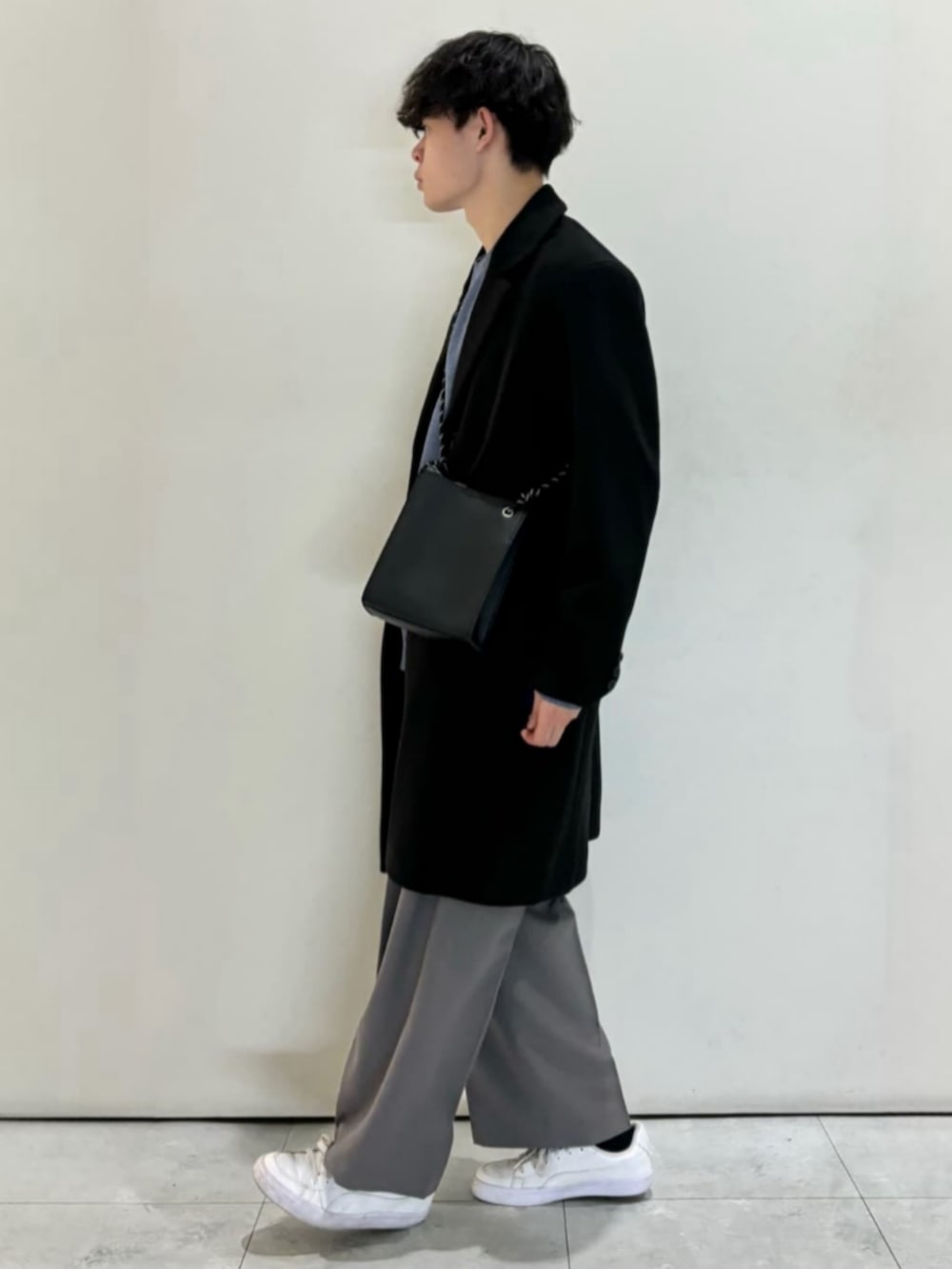 ブラック系のショルダーバッグ、グレー系のその他パンツ、ホワイト系のTシャツ/カットソーを着用したメンズの冬コーディネートの2枚目の写真