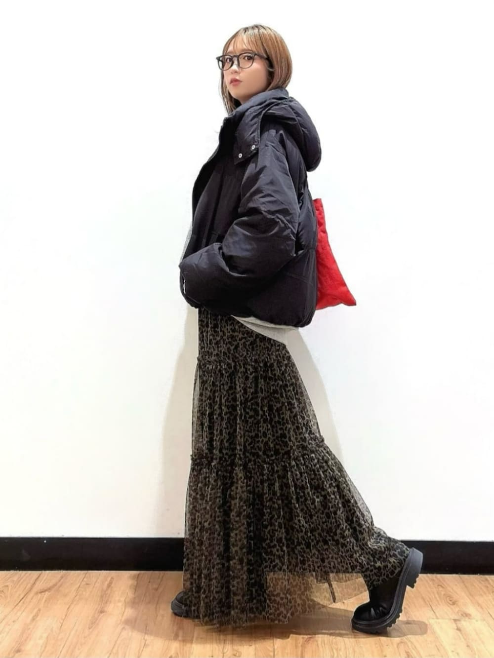 グレー系のスウェット、ブラウン系のスカート、ブラック系のTシャツ/カットソーを着用したレディースの秋コーディネートの2枚目の写真