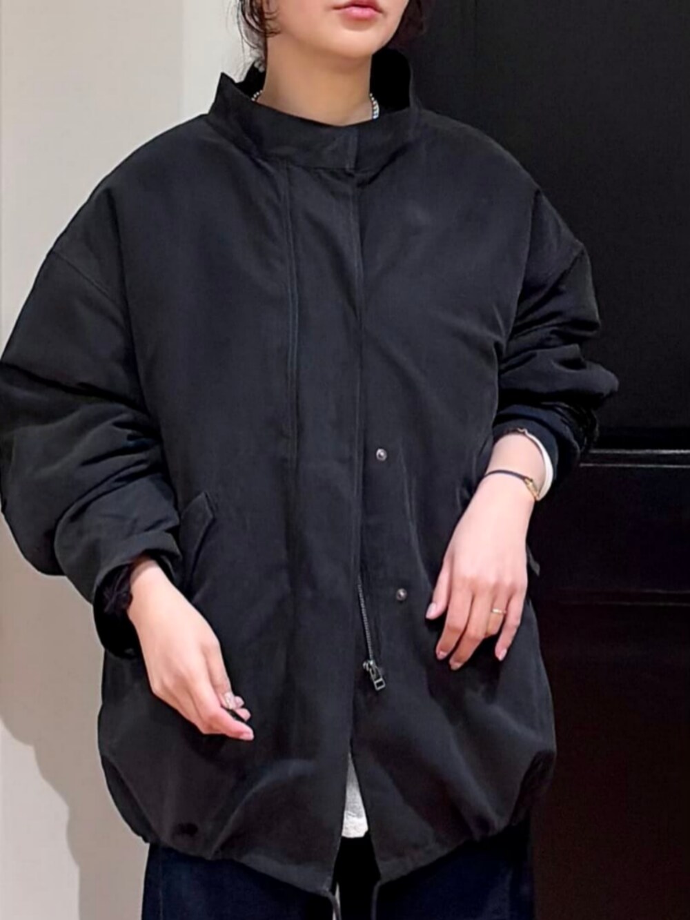 ブラウン系のショルダーバッグ、ブラック系のモッズコート、ブラック系のスウェットを着用したレディースの春コーディネートの6枚目の写真