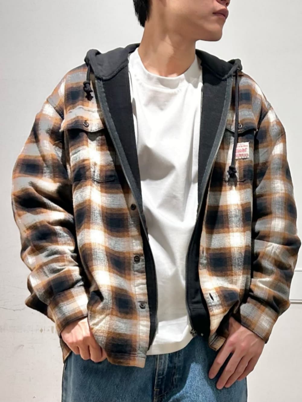 ホワイト系のTシャツ/カットソー、ブラック系のパーカー、ブルー系のデニムパンツを着用したメンズの冬コーディネートの5枚目の写真