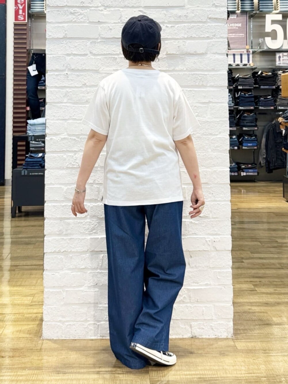 ブルー系のその他パンツ、ブラック系のトートバッグ、ホワイト系のTシャツ/カットソーを着用したレディースの夏コーディネートの6枚目の写真