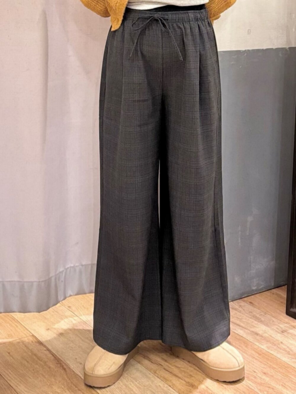 グレー系のその他パンツ、ホワイト系のダウンジャケット/コート、ブラック系のショルダーバッグを着用したレディースの冬コーディネートの9枚目の写真