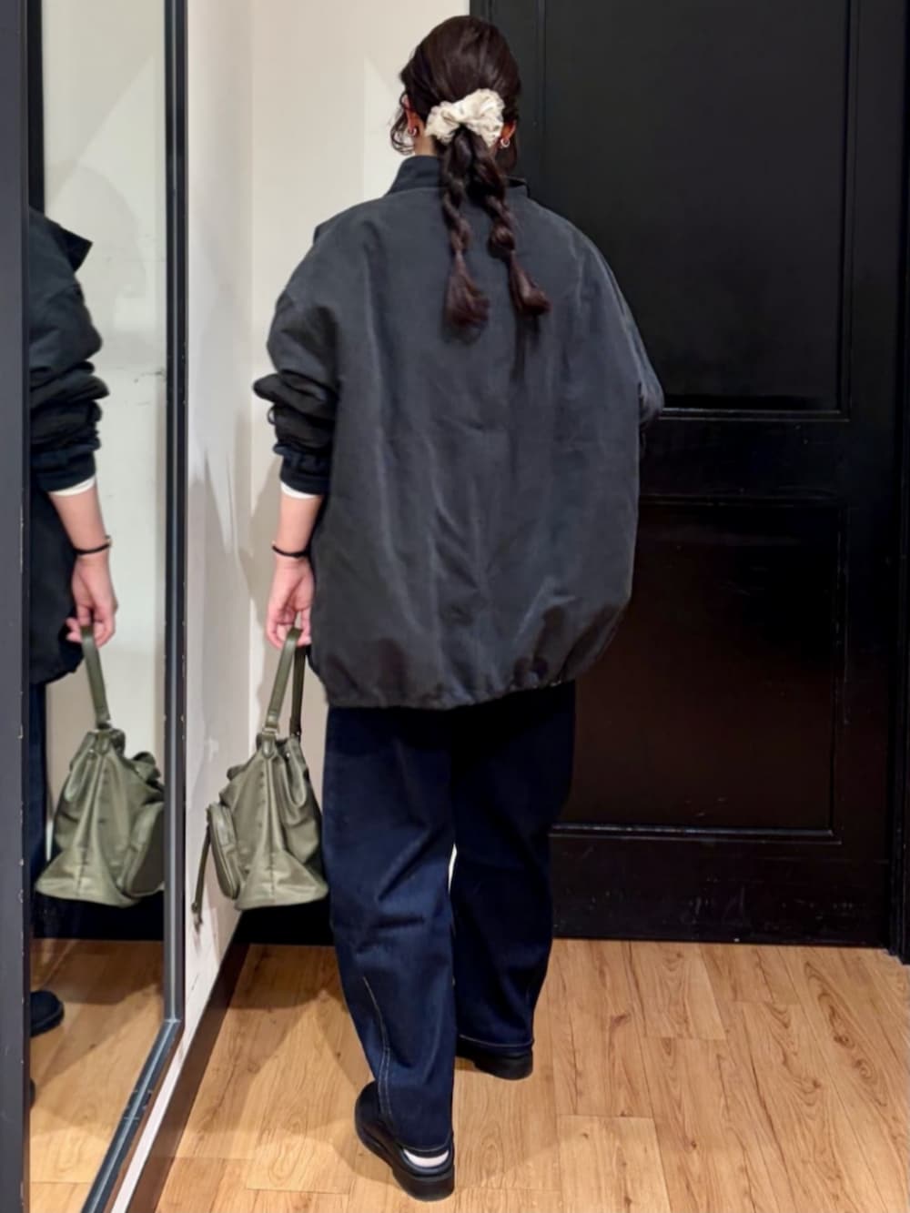 ブラウン系のショルダーバッグ、ブラック系のモッズコート、ブラック系のスウェットを着用したレディースの春コーディネートの3枚目の写真