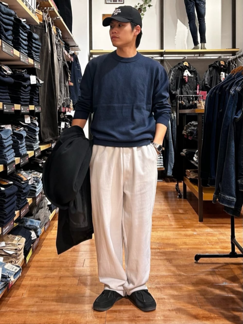 グレー系のその他パンツ、ブルー系のニット/セーター、ブラック系のチェスターコートを着用したメンズの秋コーディネートの6枚目の写真