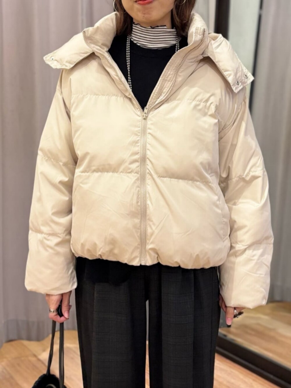 グレー系のその他パンツ、ホワイト系のダウンジャケット/コート、ブラック系のショルダーバッグを着用したレディースの冬コーディネートの4枚目の写真
