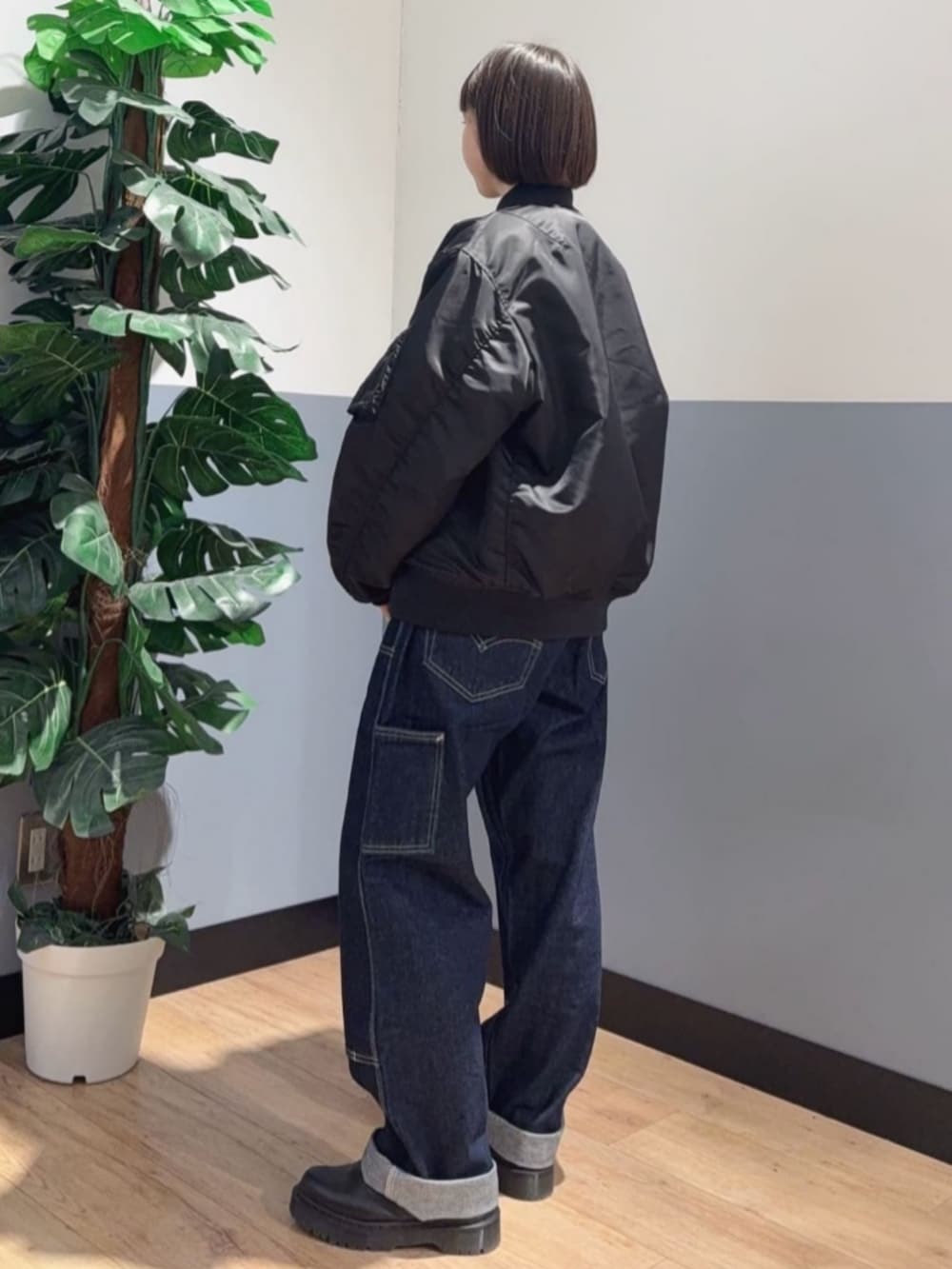 ブラック系のMA-1、イエロー系のスウェット、ブルー系のデニムパンツを着用したレディースの冬コーディネートの2枚目の写真