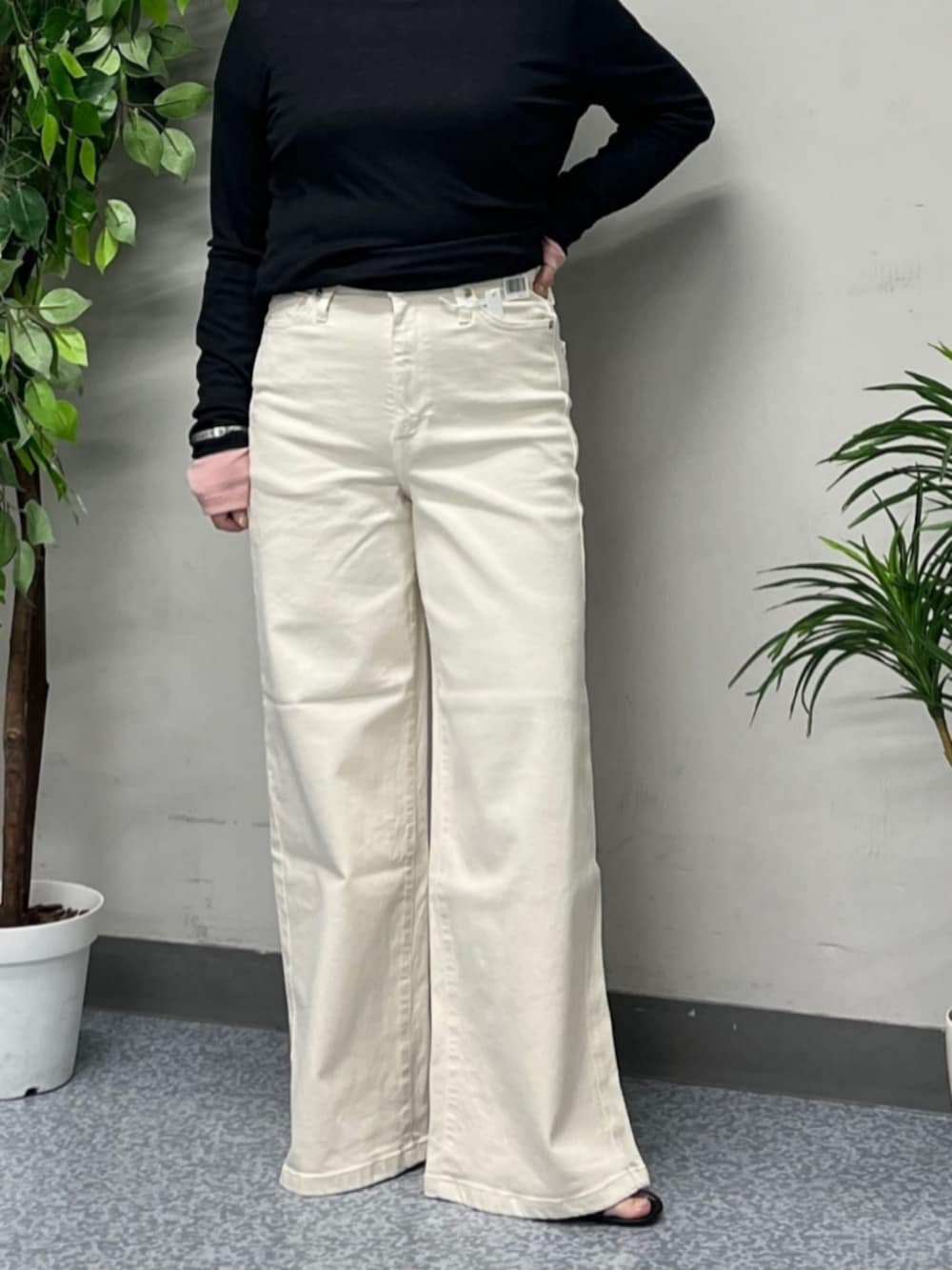 ホワイト系のトートバッグ、ベージュ系のマウンテンパーカー、ホワイト系のデニムパンツを着用したレディースの春コーディネートの5枚目の写真