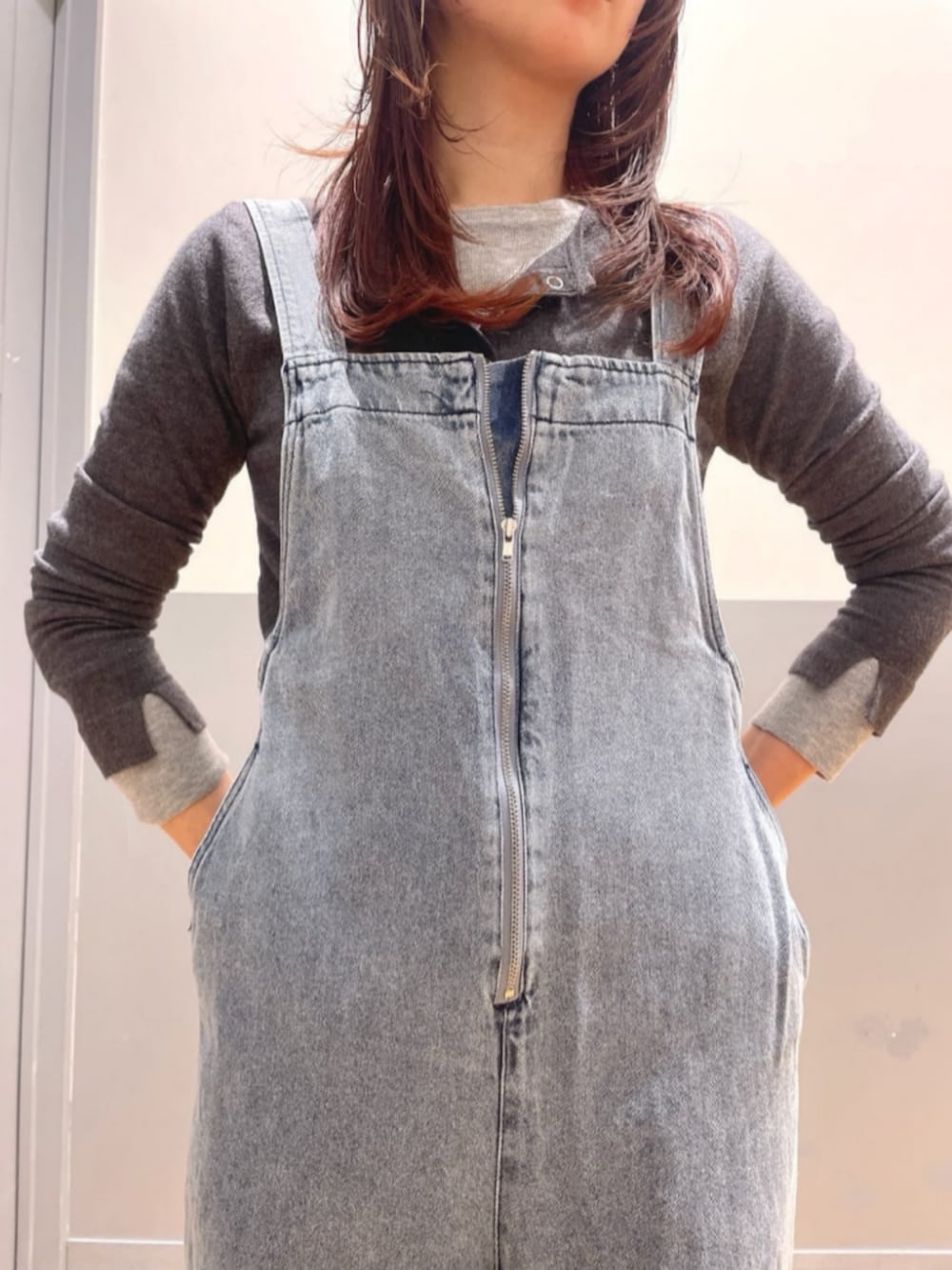 グレー系のパーカー、ブルー系のサロペット/オーバーオール、レッド系のキャップを着用したレディースの春コーディネートの8枚目の写真