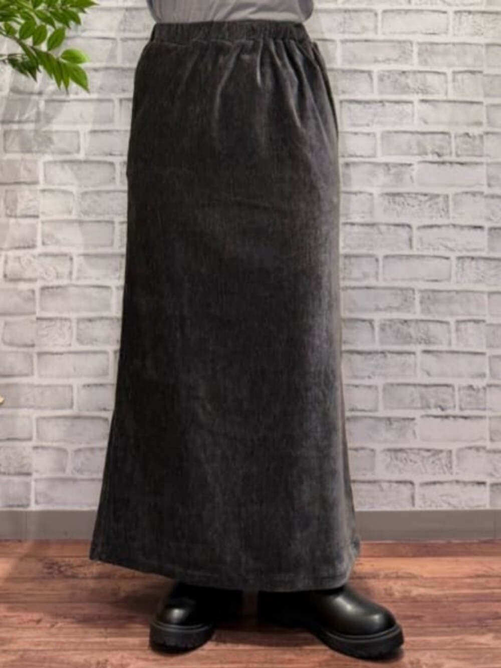 グレー系のスカート、ブラウン系のベスト、ブラック系のニット/セーターを着用したレディースの秋コーディネートの6枚目の写真