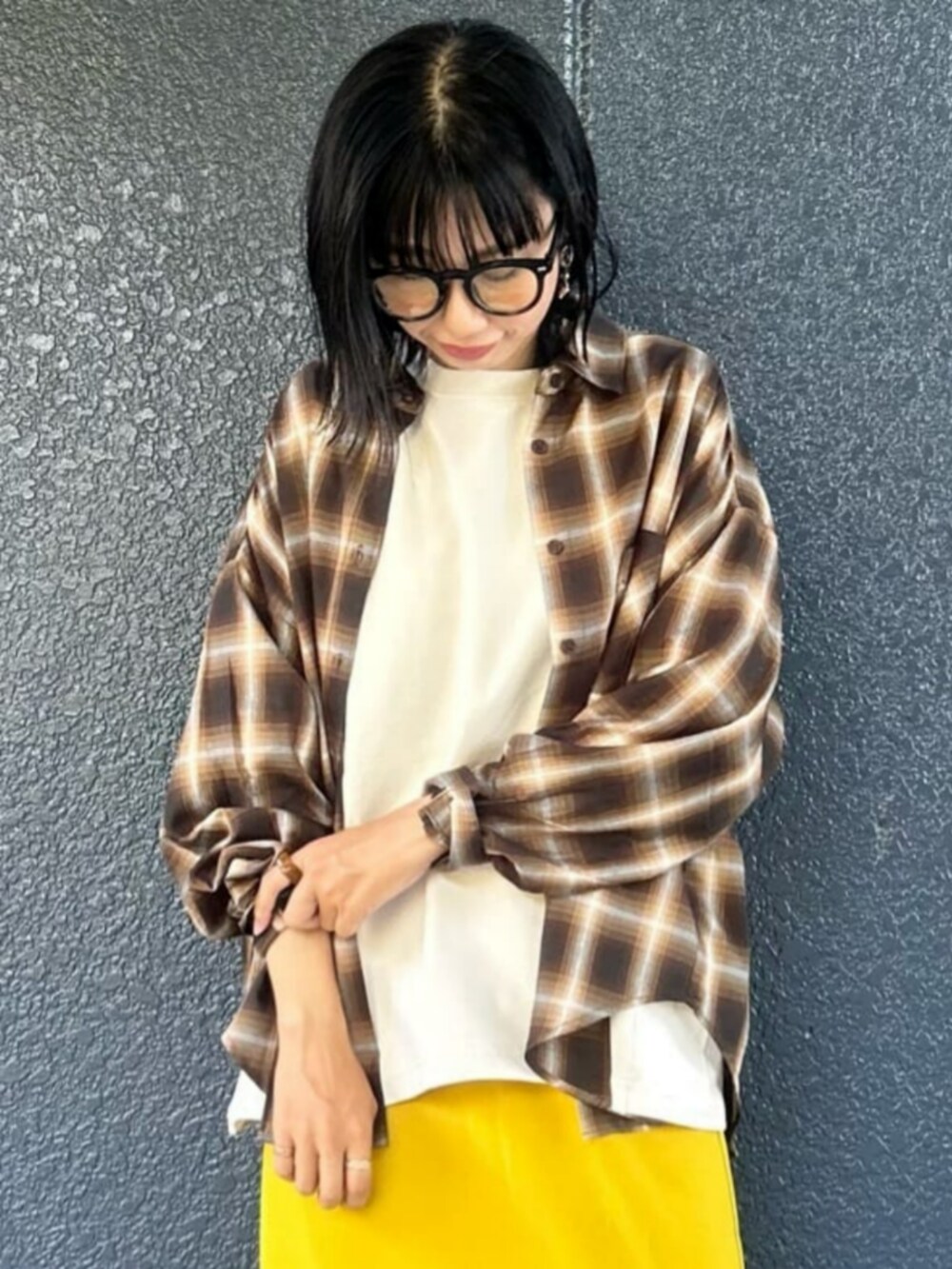 イエロー系のスカート、ホワイト系のTシャツ/カットソー、ブラウン系のシャツ/ブラウスを着用したレディースの秋コーディネートの5枚目の写真