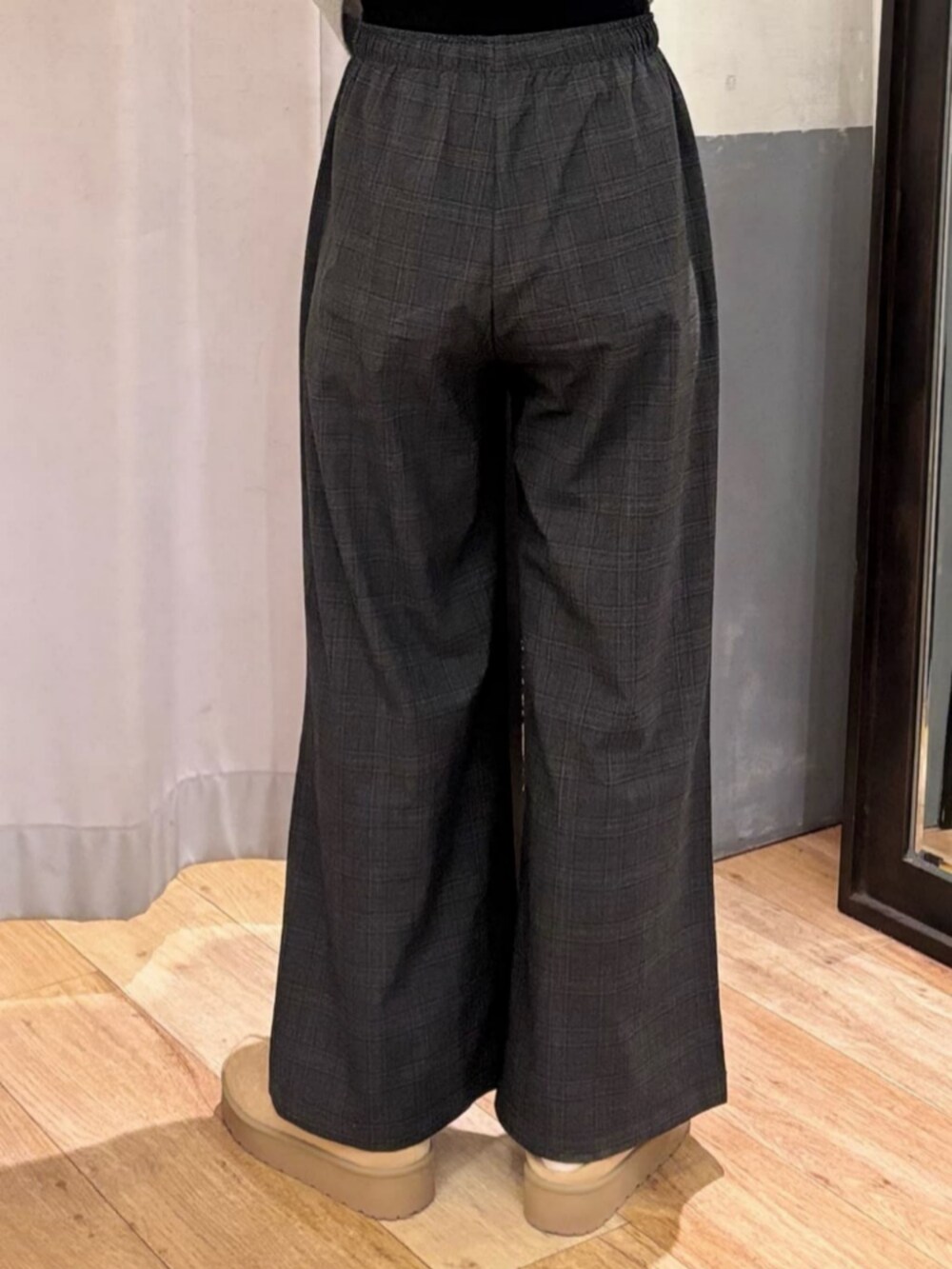 グレー系のその他パンツ、ホワイト系のダウンジャケット/コート、ブラック系のショルダーバッグを着用したレディースの冬コーディネートの10枚目の写真