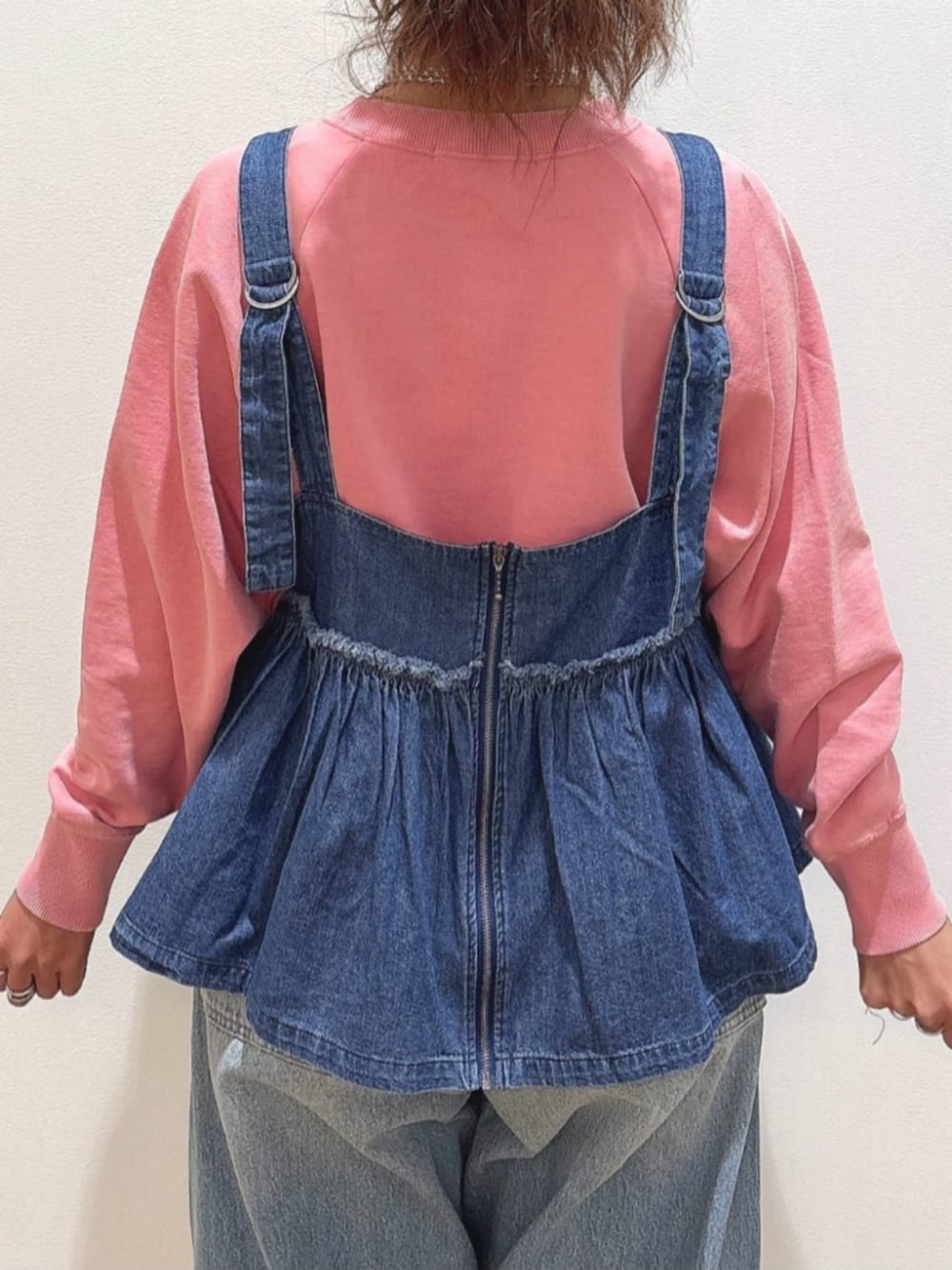 ピンク系のスウェット、ブルー系のその他トップス、ブルー系のデニムパンツを着用したレディースの冬コーディネートの7枚目の写真