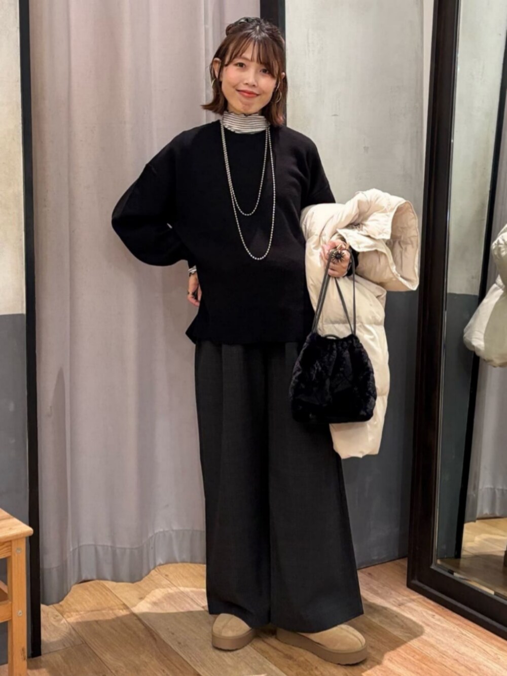 グレー系のその他パンツ、ホワイト系のダウンジャケット/コート、ブラック系のショルダーバッグを着用したレディースの冬コーディネートの6枚目の写真