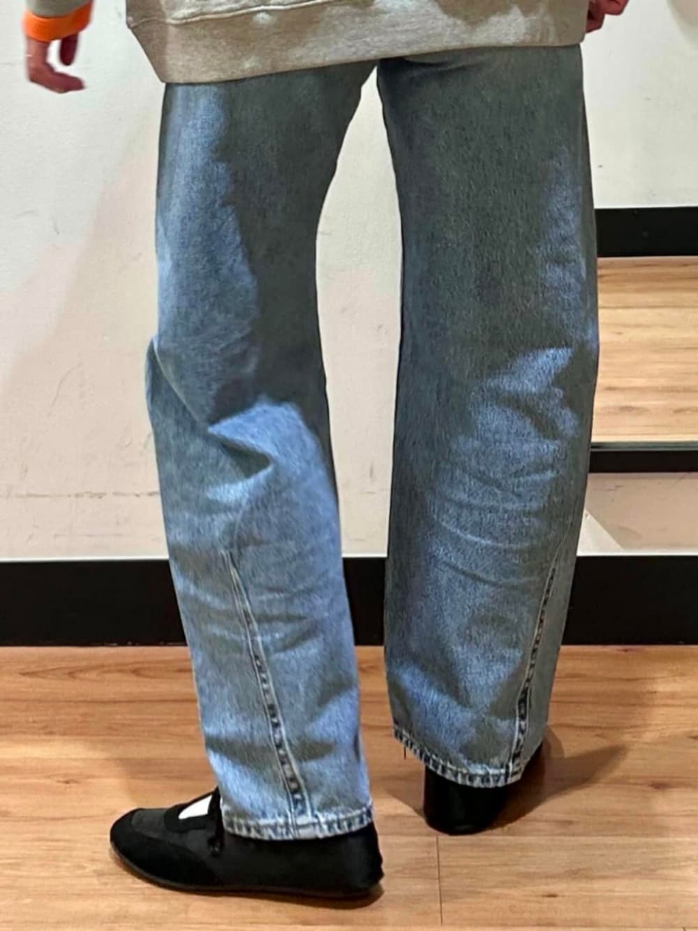 グレー系のスウェット、ブラック系のショルダーバッグ、ブルー系のデニムパンツを着用したレディースの冬コーディネートの9枚目の写真