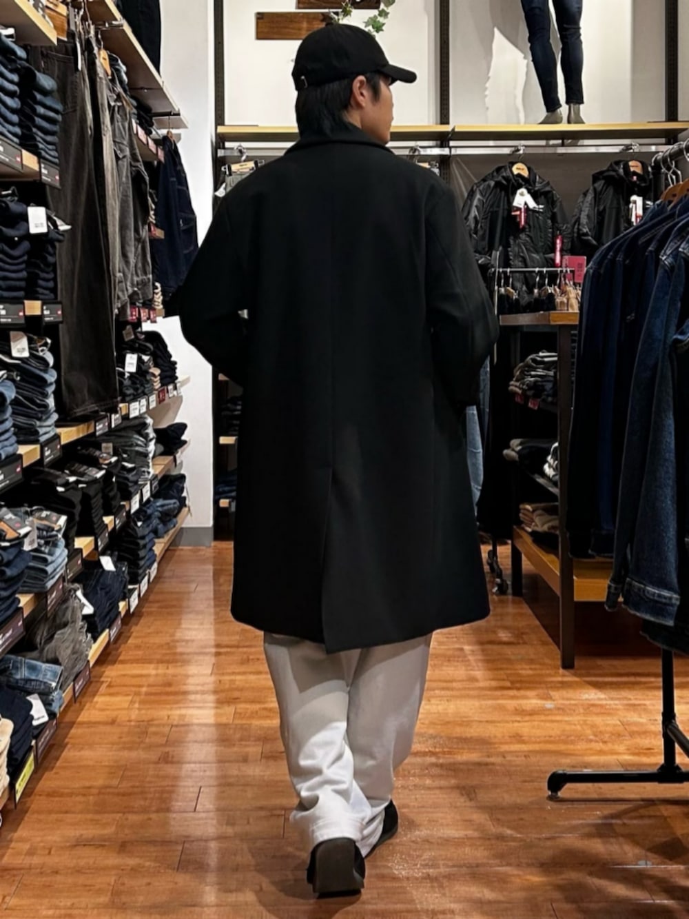 グレー系のその他パンツ、ブルー系のニット/セーター、ブラック系のチェスターコートを着用したメンズの秋コーディネートの3枚目の写真