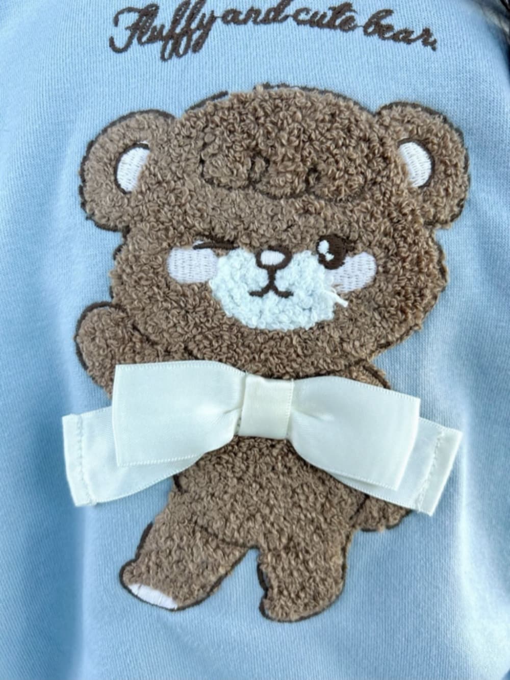 ホワイト系のトートバッグ、ブルー系のスウェット、ホワイト系のブルゾンを着用したキッズの冬コーディネートの6枚目の写真