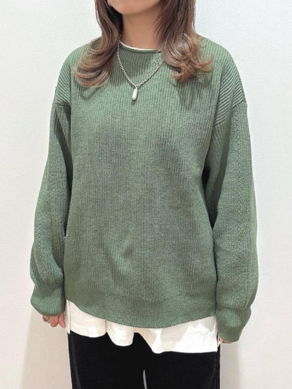 ブラウン系のショルダーバッグ、ブラウン系のその他アウター、グリーン系のニット/セーターを着用したレディースの冬コーディネートの7枚目の写真