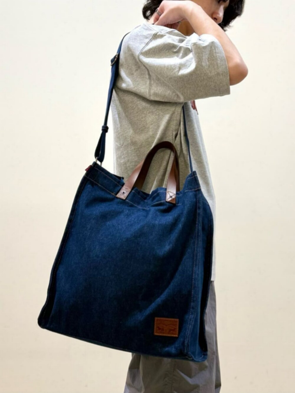 ブルー系のトートバッグ、ホワイト系のTシャツ/カットソー、ブラック系のカーゴパンツを着用したレディースの夏コーディネートの7枚目の写真