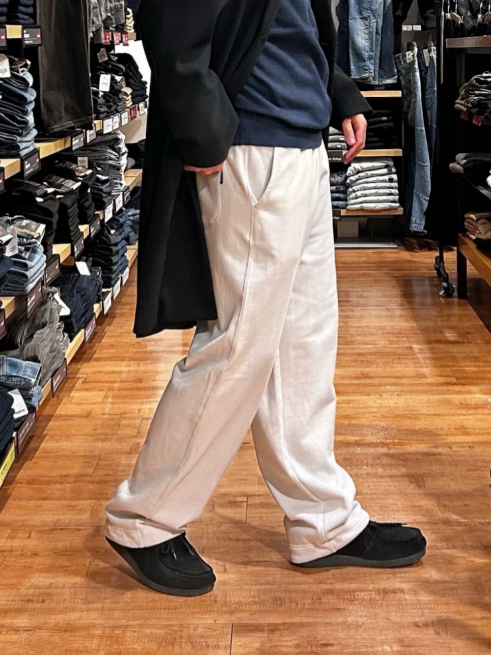 グレー系のその他パンツ、ブルー系のニット/セーター、ブラック系のチェスターコートを着用したメンズの秋コーディネートの9枚目の写真