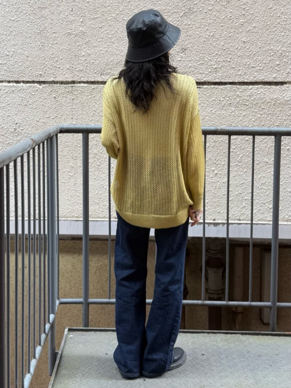 ホワイト系のTシャツ/カットソー、イエロー系のニット/セーター、ブルー系のデニムパンツを着用したレディースの春コーディネートの3枚目の写真