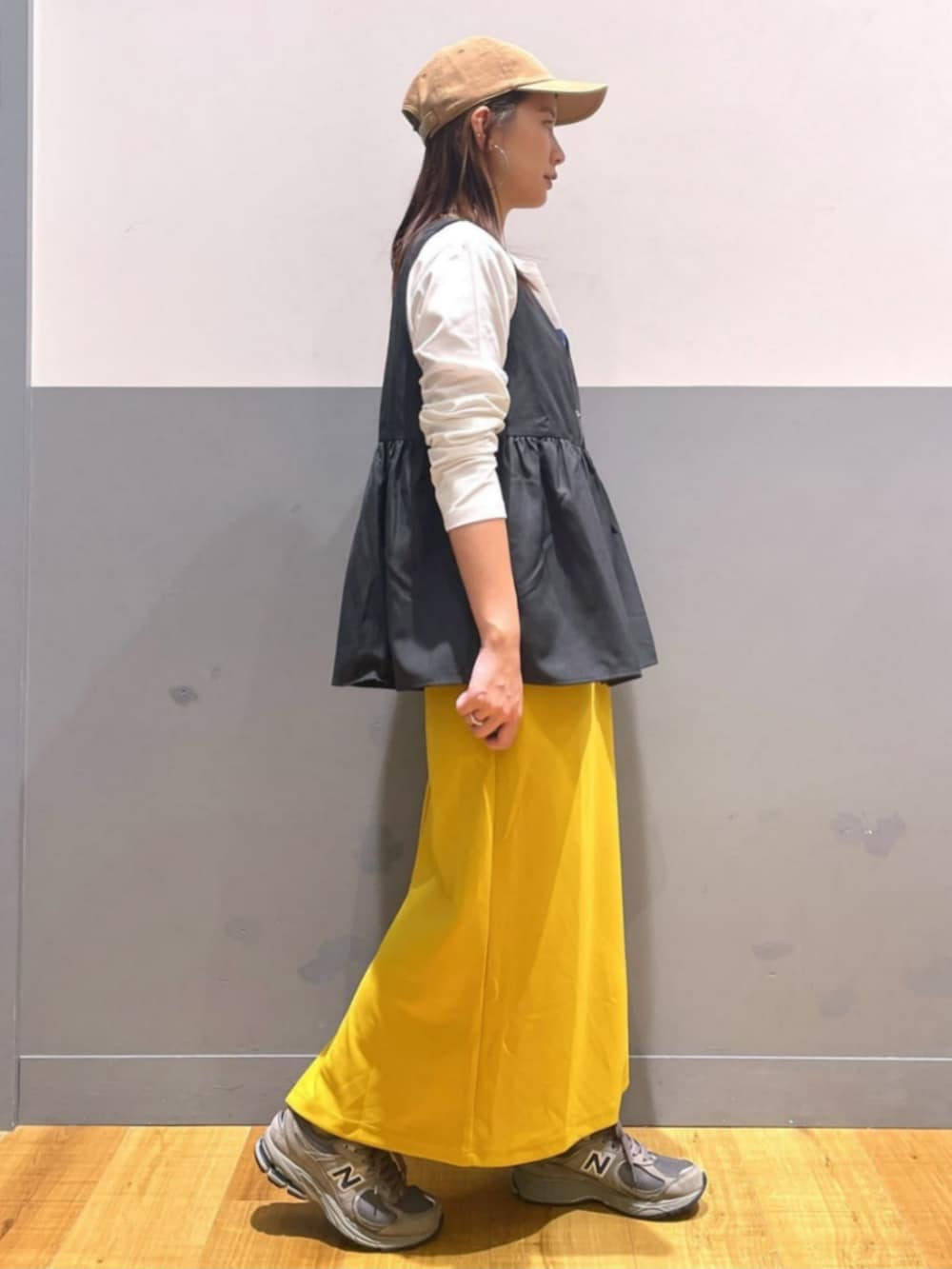 イエロー系のスカート、ホワイト系のTシャツ/カットソー、グレー系のその他トップスを着用したレディースの秋コーディネートの2枚目の写真