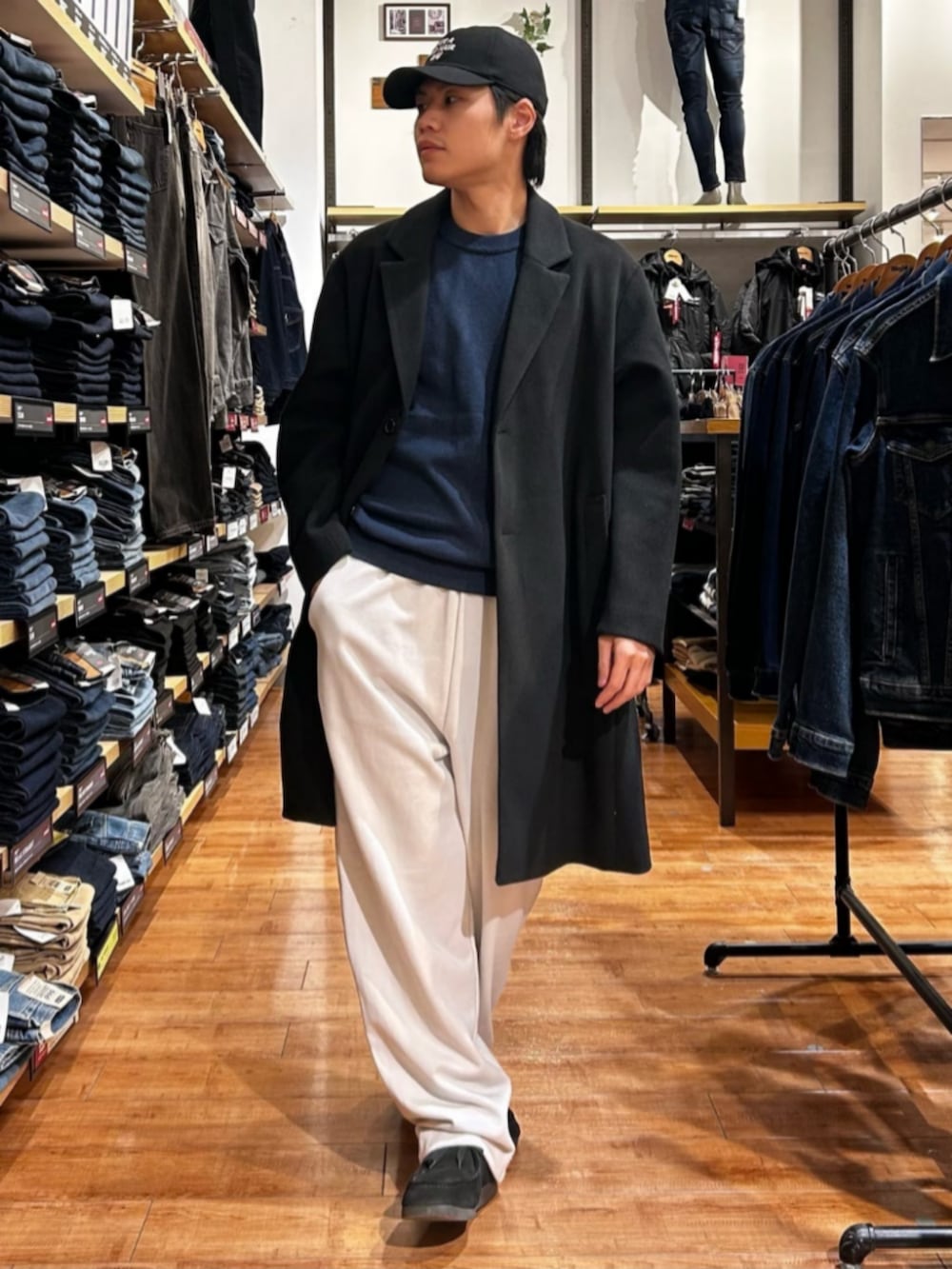 グレー系のその他パンツ、ブルー系のニット/セーター、ブラック系のチェスターコートを着用したメンズの秋コーディネートの4枚目の写真