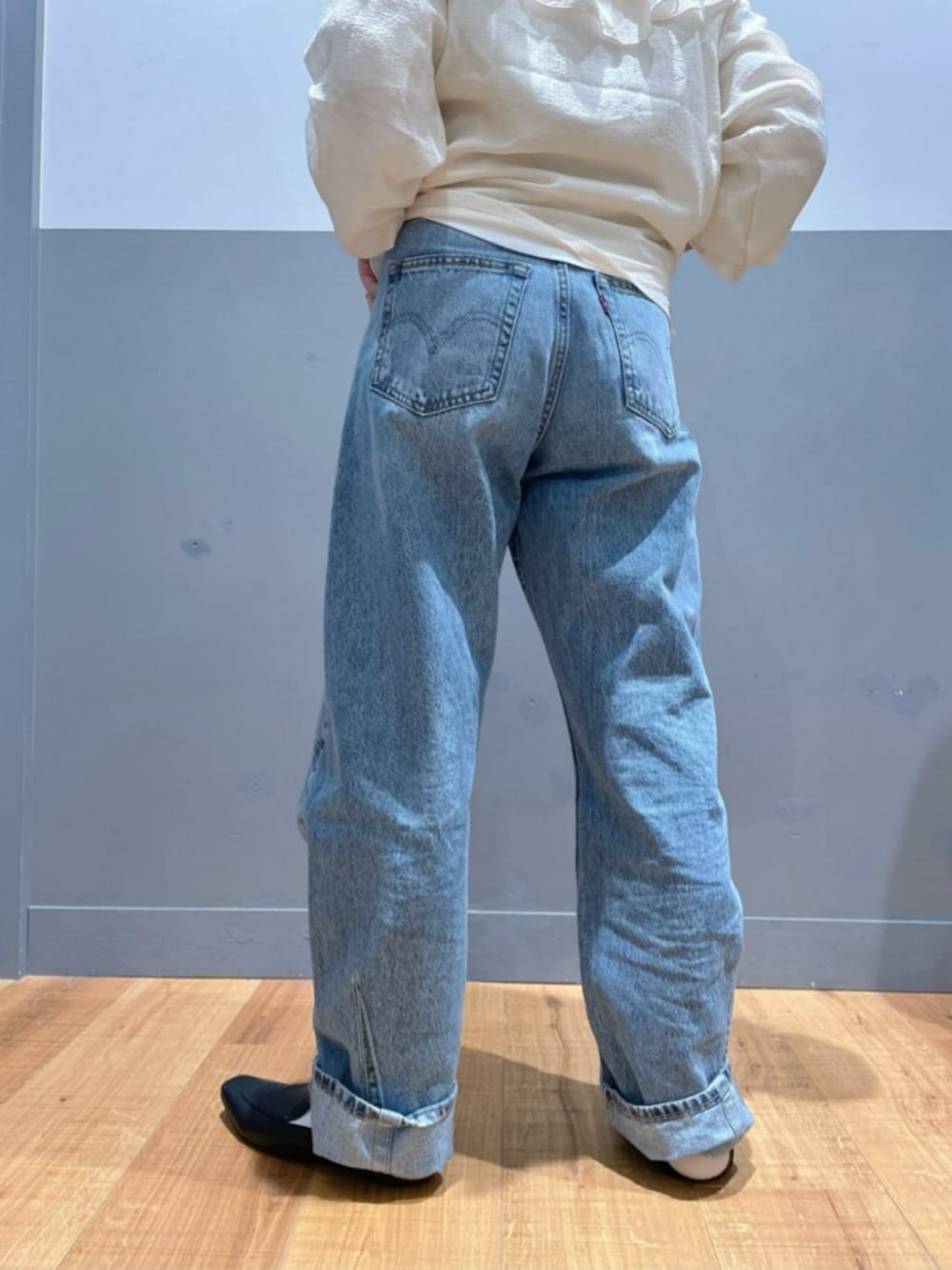 ブラック系のショルダーバッグ、ホワイト系のTシャツ/カットソー、ブルー系のデニムパンツを着用したレディースの秋コーディネートの7枚目の写真