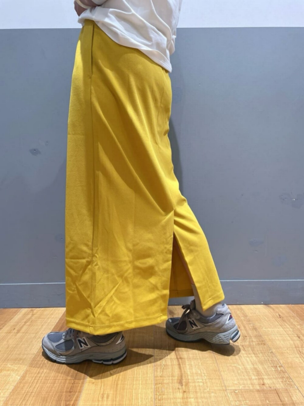 イエロー系のスカート、ホワイト系のTシャツ/カットソー、グレー系のその他トップスを着用したレディースの秋コーディネートの9枚目の写真