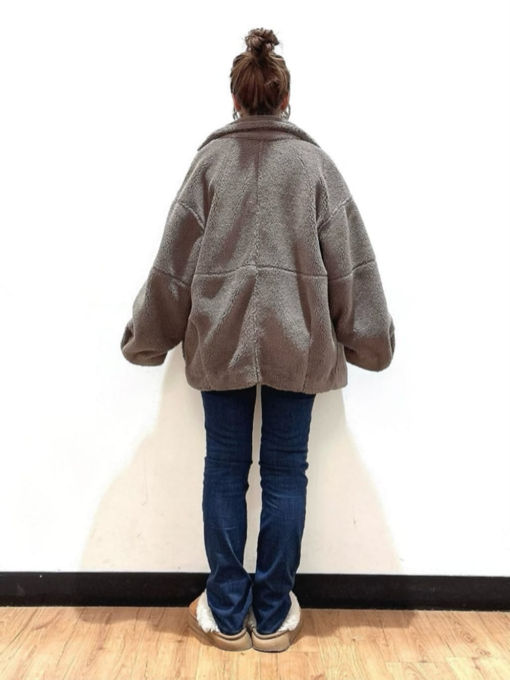 ブラウン系のショルダーバッグ、ブラウン系のその他アウター、グリーン系のニット/セーターを着用したレディースの冬コーディネートの3枚目の写真