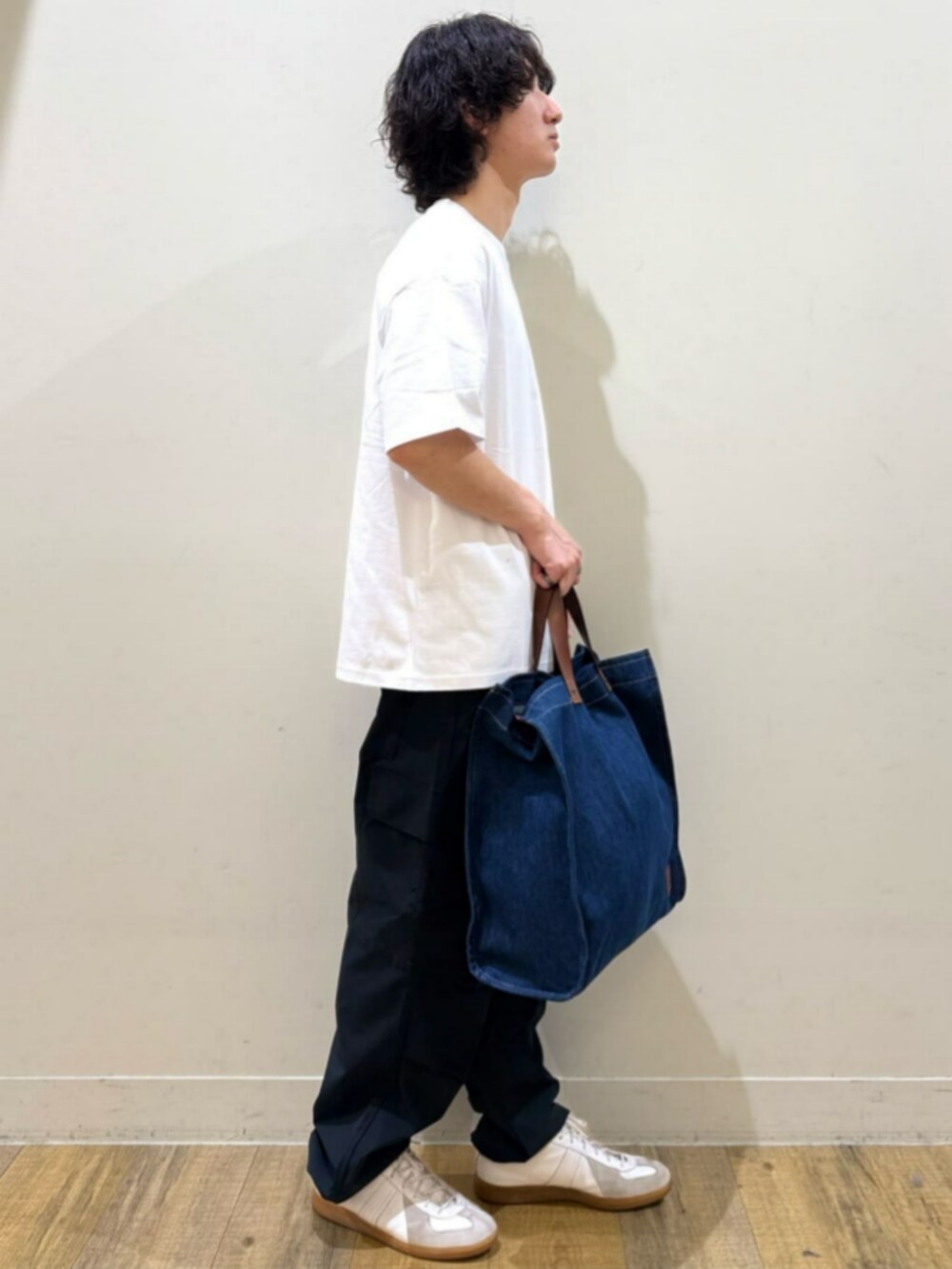 ブルー系のトートバッグ、ホワイト系のTシャツ/カットソー、ブラック系のカーゴパンツを着用したレディースの夏コーディネートの3枚目の写真