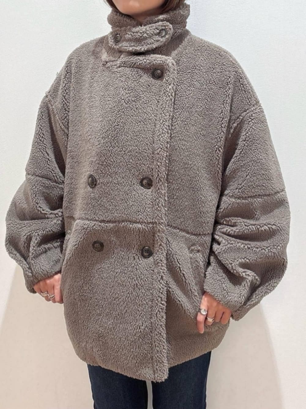 ブラウン系のショルダーバッグ、ブラウン系のその他アウター、グリーン系のニット/セーターを着用したレディースの冬コーディネートの6枚目の写真