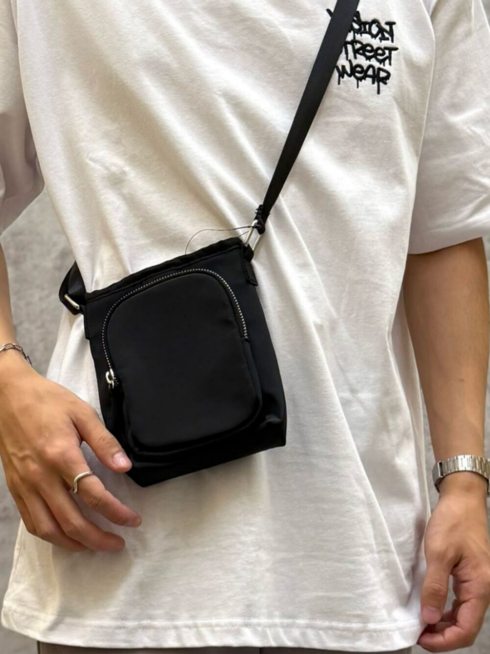 ホワイト系のTシャツ/カットソー、グレー系のその他パンツ、ブラック系のショルダーバッグを着用したメンズの夏コーディネートの7枚目の写真