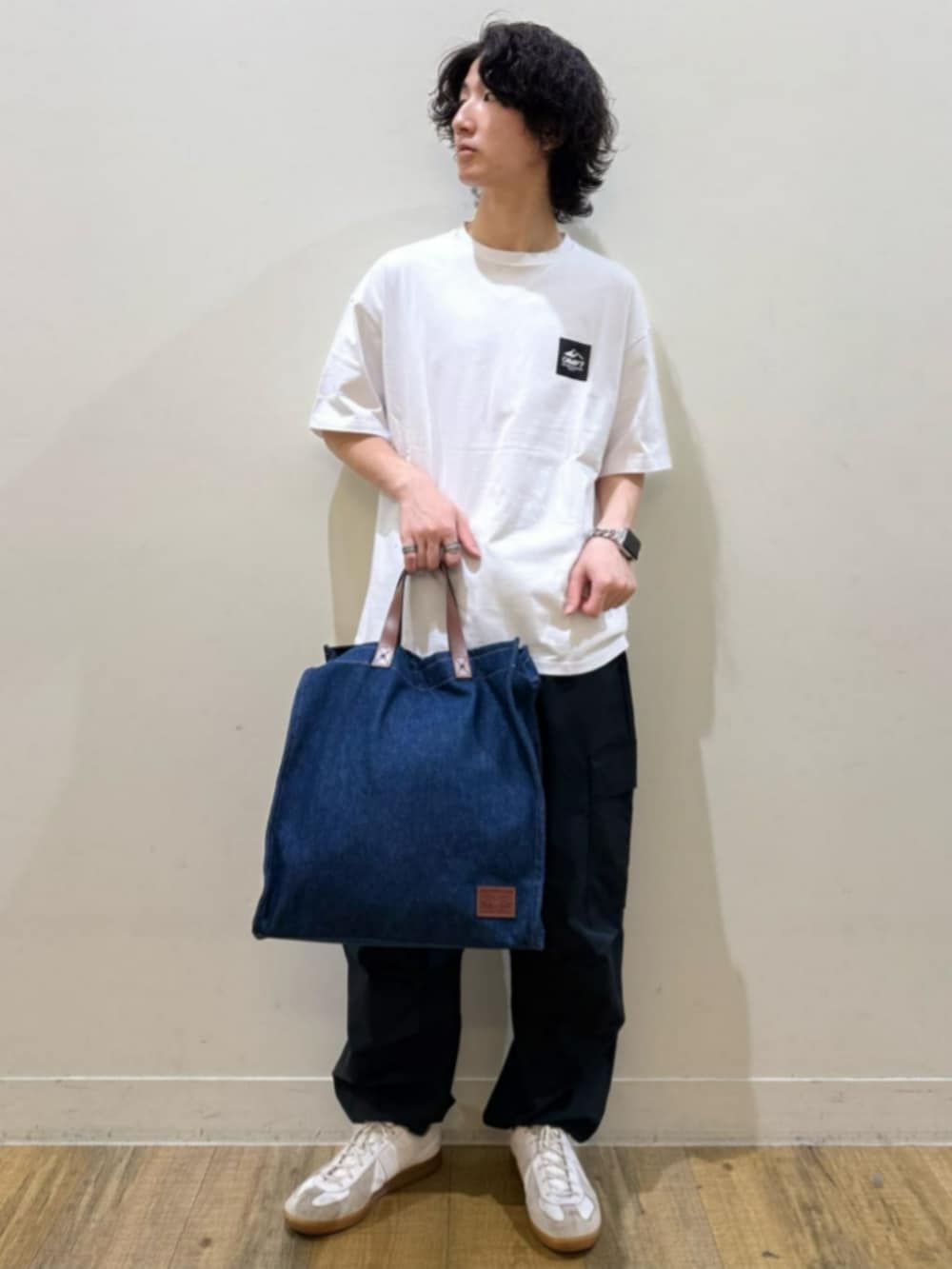 ブルー系のトートバッグ、ホワイト系のTシャツ/カットソー、ブラック系のカーゴパンツを着用したレディースの夏コーディネートの2枚目の写真