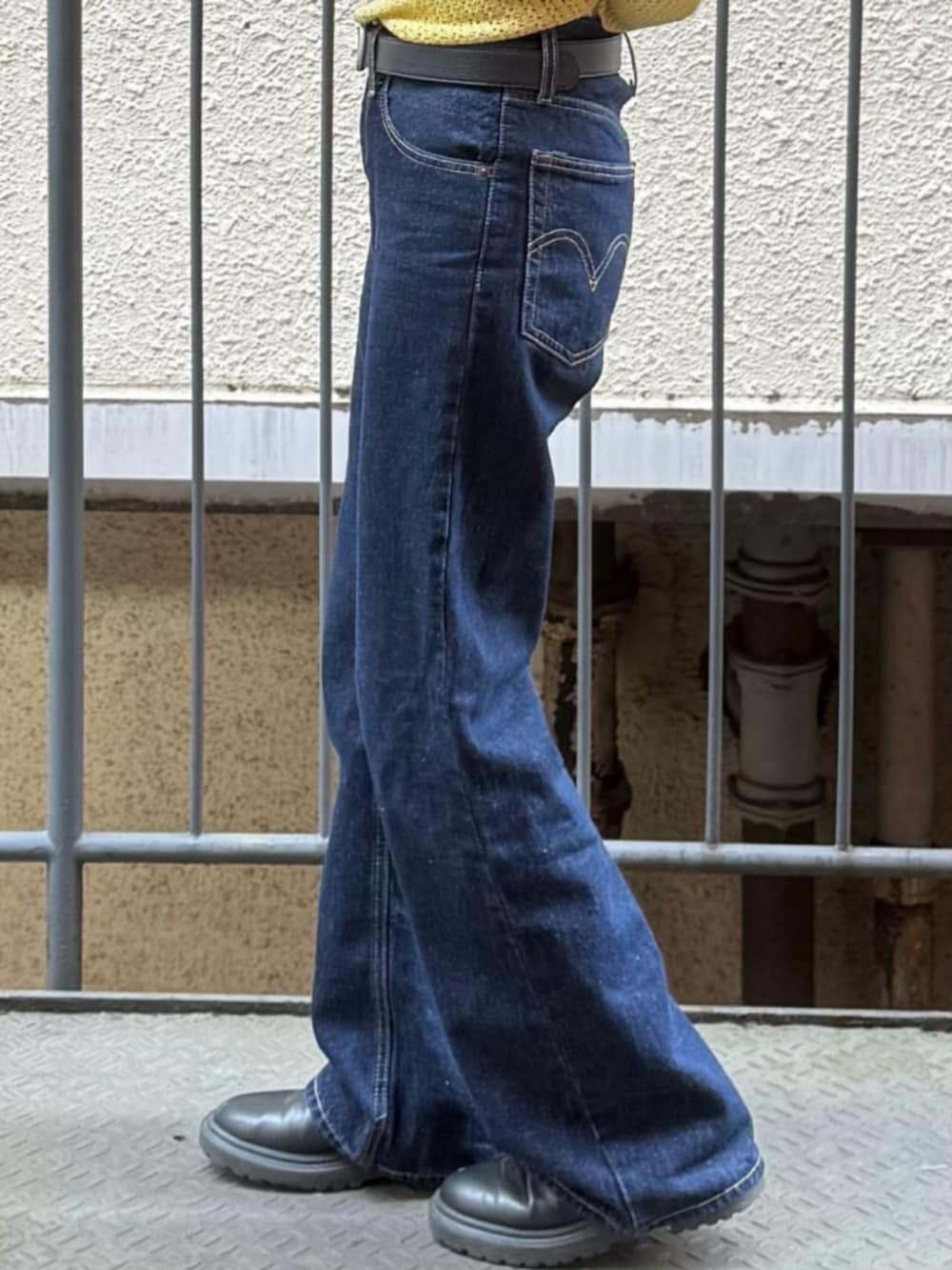 ホワイト系のTシャツ/カットソー、イエロー系のニット/セーター、ブルー系のデニムパンツを着用したレディースの春コーディネートの6枚目の写真