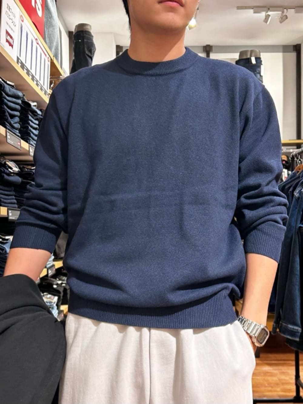 グレー系のその他パンツ、ブルー系のニット/セーター、ブラック系のチェスターコートを着用したメンズの秋コーディネートの7枚目の写真