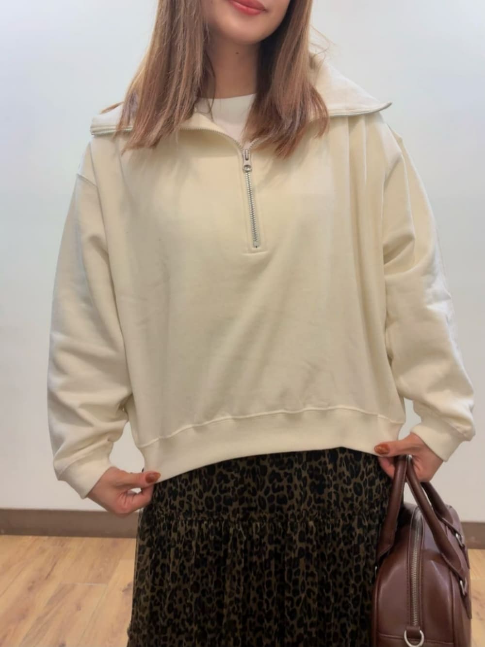 ブラウン系のショルダーバッグ、ホワイト系のスウェット、ブラウン系のスカートを着用したレディースの秋コーディネートの4枚目の写真