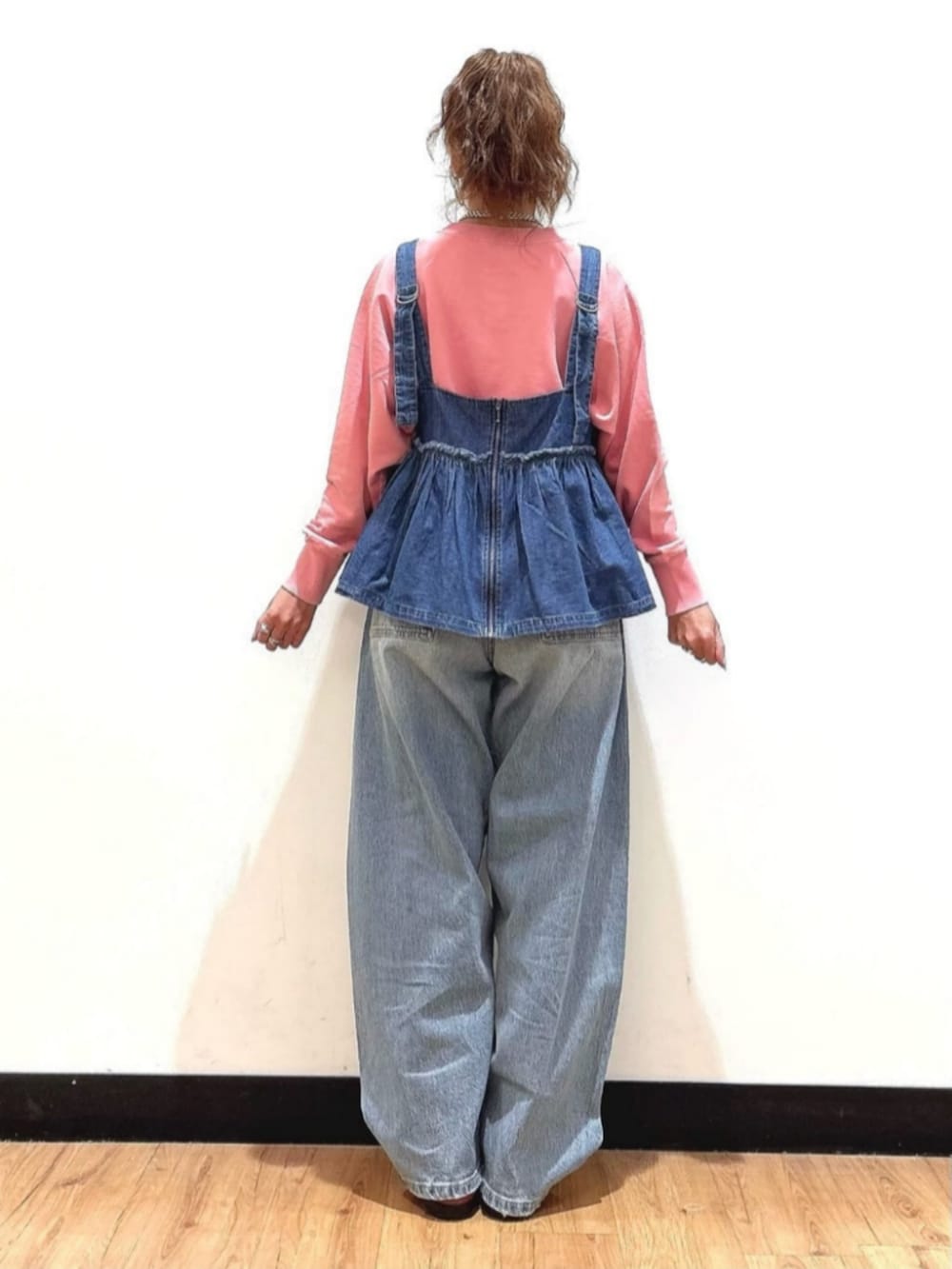 ピンク系のスウェット、ブルー系のその他トップス、ブルー系のデニムパンツを着用したレディースの冬コーディネートの3枚目の写真