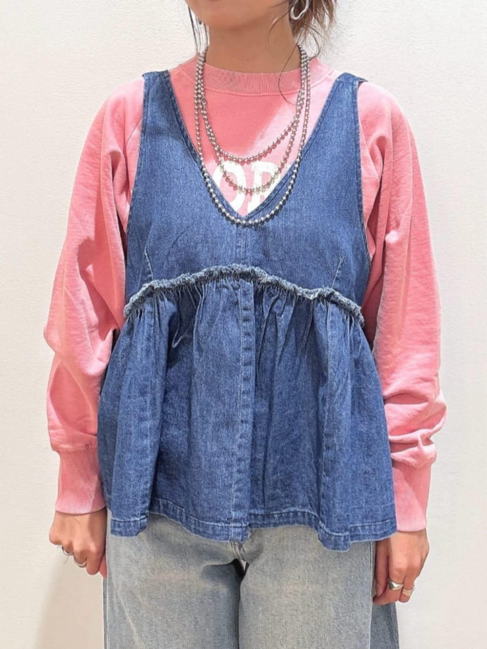 ピンク系のスウェット、ブルー系のその他トップス、ブルー系のデニムパンツを着用したレディースの冬コーディネートの5枚目の写真