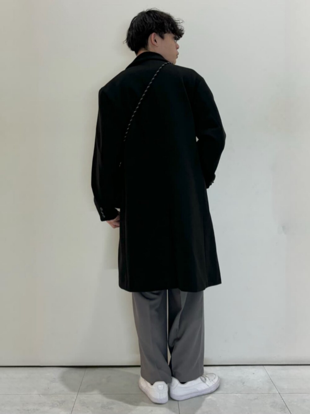 ブラック系のショルダーバッグ、グレー系のその他パンツ、ホワイト系のTシャツ/カットソーを着用したメンズの冬コーディネートの3枚目の写真