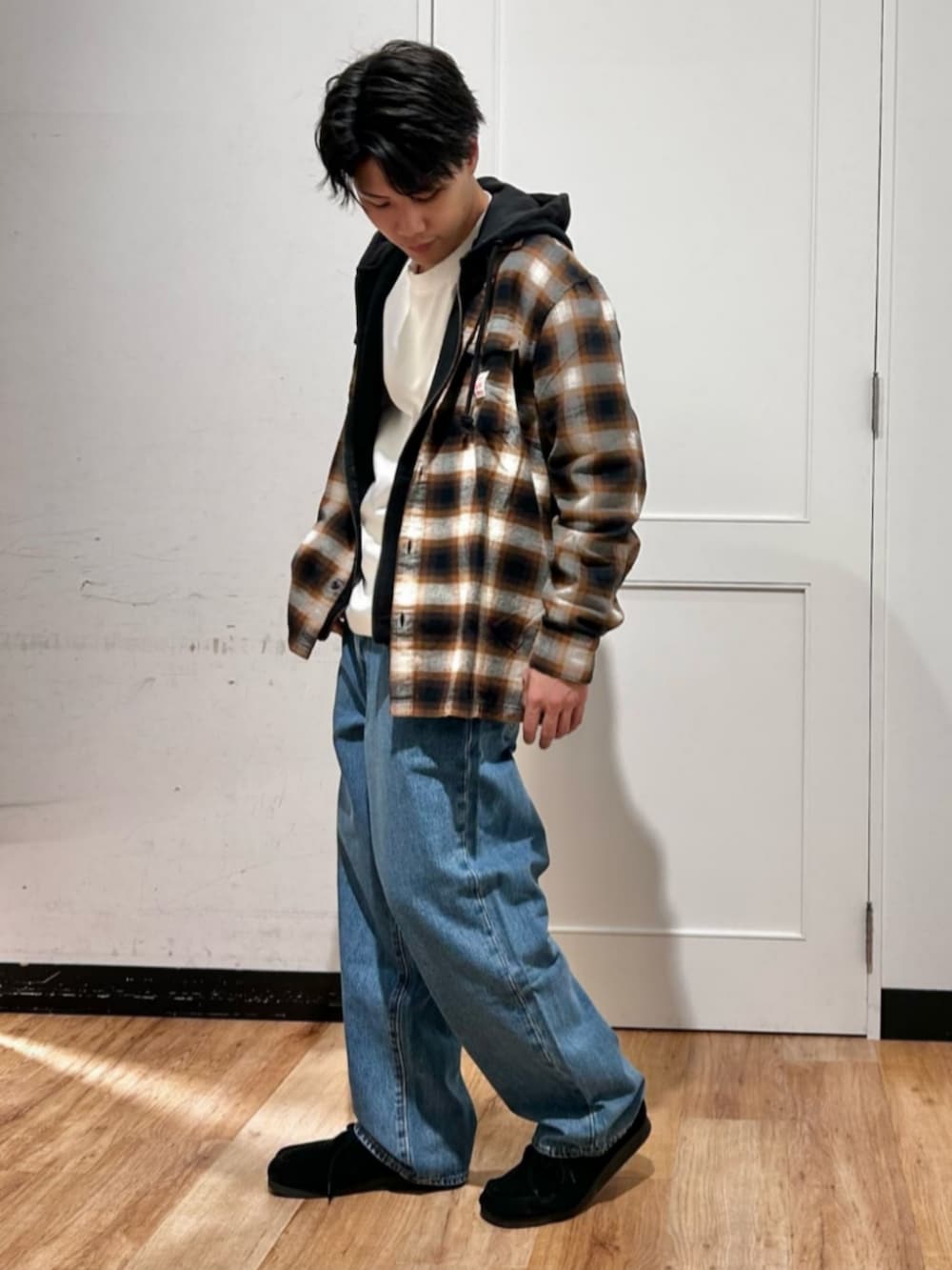 ホワイト系のTシャツ/カットソー、ブラック系のパーカー、ブルー系のデニムパンツを着用したメンズの冬コーディネートの4枚目の写真