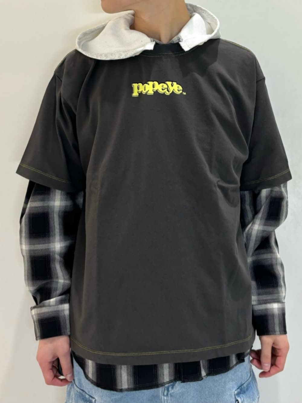 ブルー系のデニムパンツ、ブラック系のシャツ/ブラウス、グレー系のTシャツ/カットソーを着用したメンズの春コーディネートの5枚目の写真