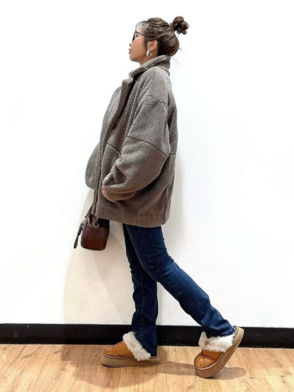 ブラウン系のショルダーバッグ、ブラウン系のその他アウター、グリーン系のニット/セーターを着用したレディースの冬コーディネートの2枚目の写真