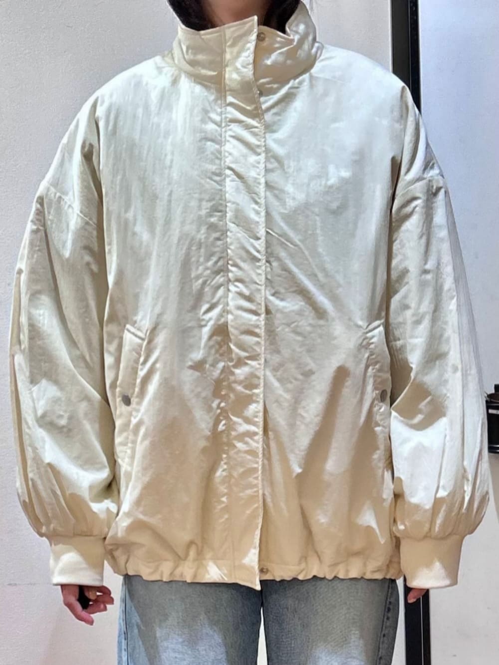 グレー系のスウェット、ブラック系のショルダーバッグ、ブルー系のデニムパンツを着用したレディースの冬コーディネートの7枚目の写真