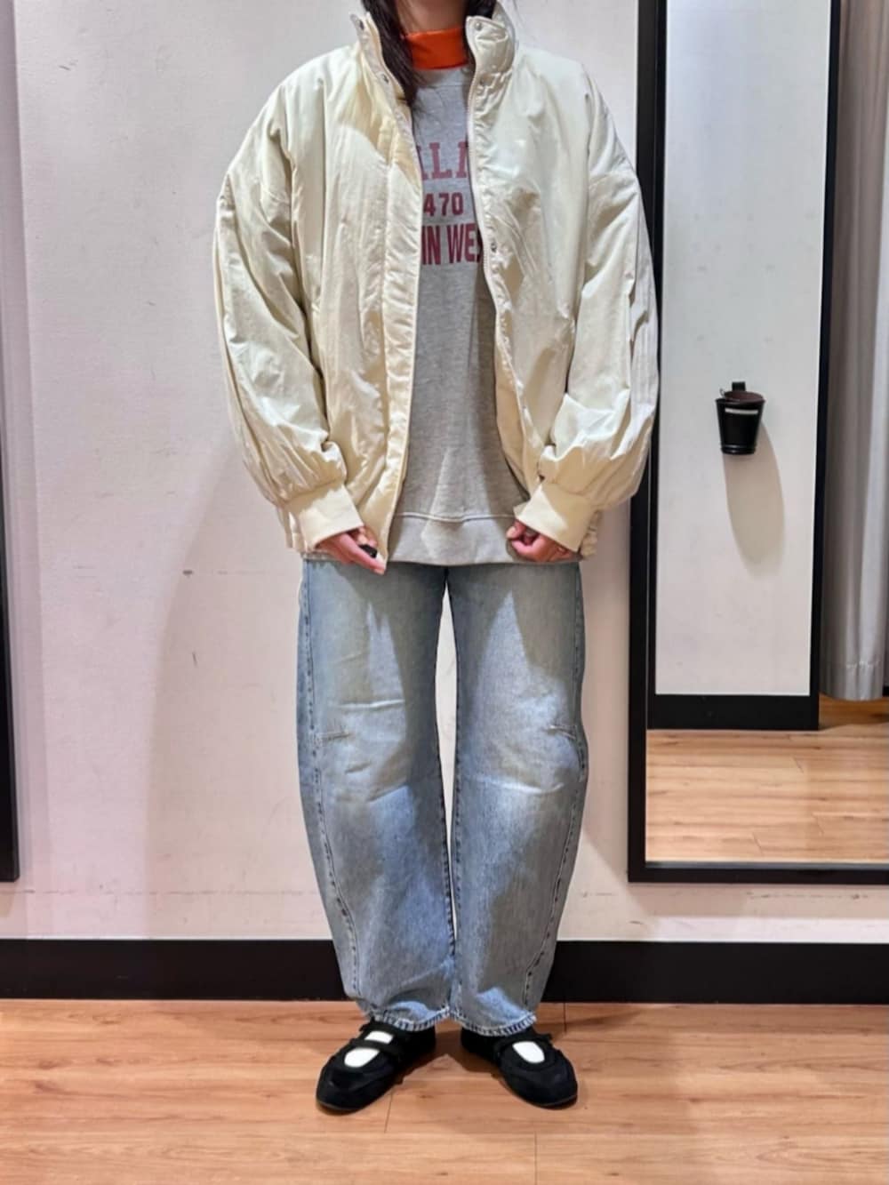 グレー系のスウェット、ブラック系のショルダーバッグ、ブルー系のデニムパンツを着用したレディースの冬コーディネートの4枚目の写真