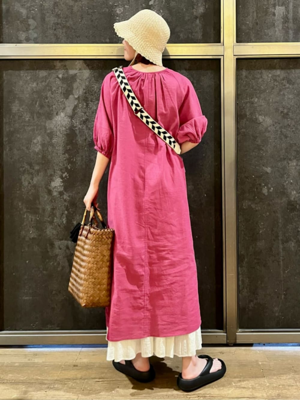 ブラック系のサンダル、ピンク系のシャツワンピース、ホワイト系のスカートを着用したレディースの夏コーディネートの3枚目の写真