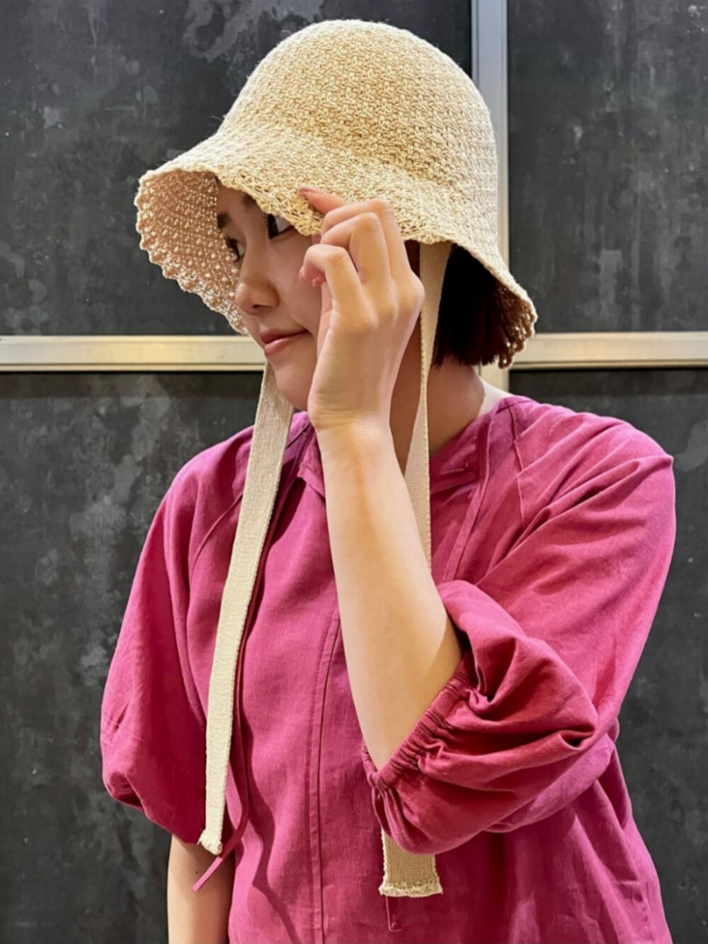 ブラック系のサンダル、ピンク系のシャツワンピース、ホワイト系のスカートを着用したレディースの夏コーディネートの9枚目の写真