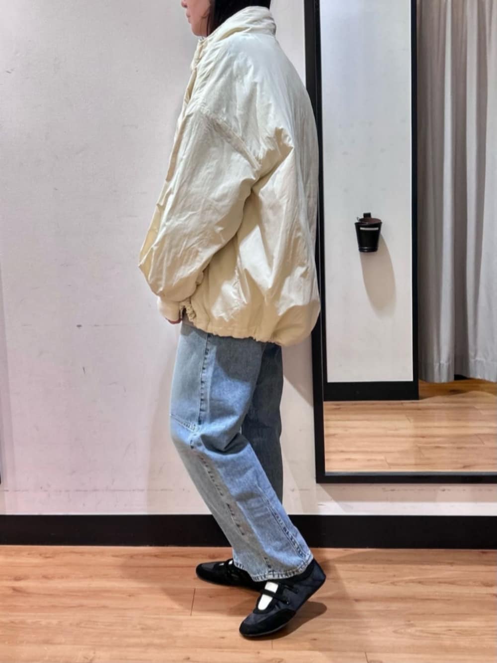 グレー系のスウェット、ブラック系のショルダーバッグ、ブルー系のデニムパンツを着用したレディースの冬コーディネートの5枚目の写真