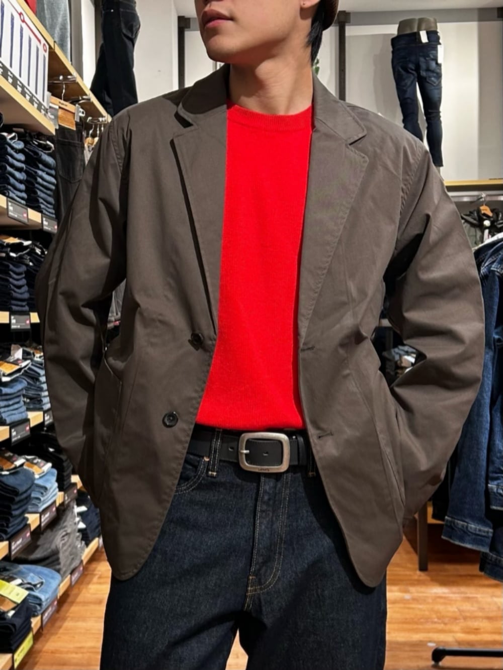 ブルー系のデニムパンツ、レッド系のニット/セーター、ブラウン系のテーラードジャケットを着用したメンズの冬コーディネートの6枚目の写真