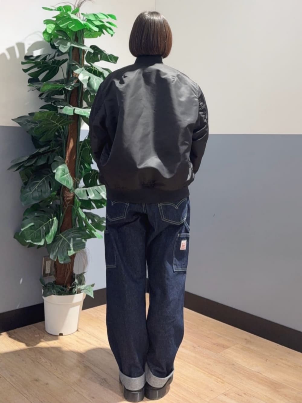 ブラック系のMA-1、イエロー系のスウェット、ブルー系のデニムパンツを着用したレディースの冬コーディネートの4枚目の写真