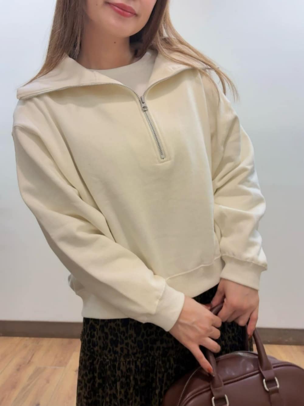 ブラウン系のショルダーバッグ、ホワイト系のスウェット、ブラウン系のスカートを着用したレディースの秋コーディネートの5枚目の写真